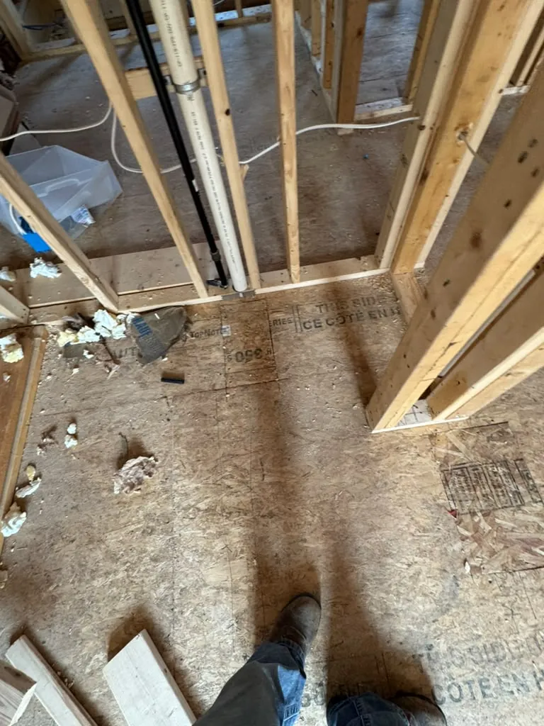 Framed opening for the new bathroom with the drain and supply lines already run