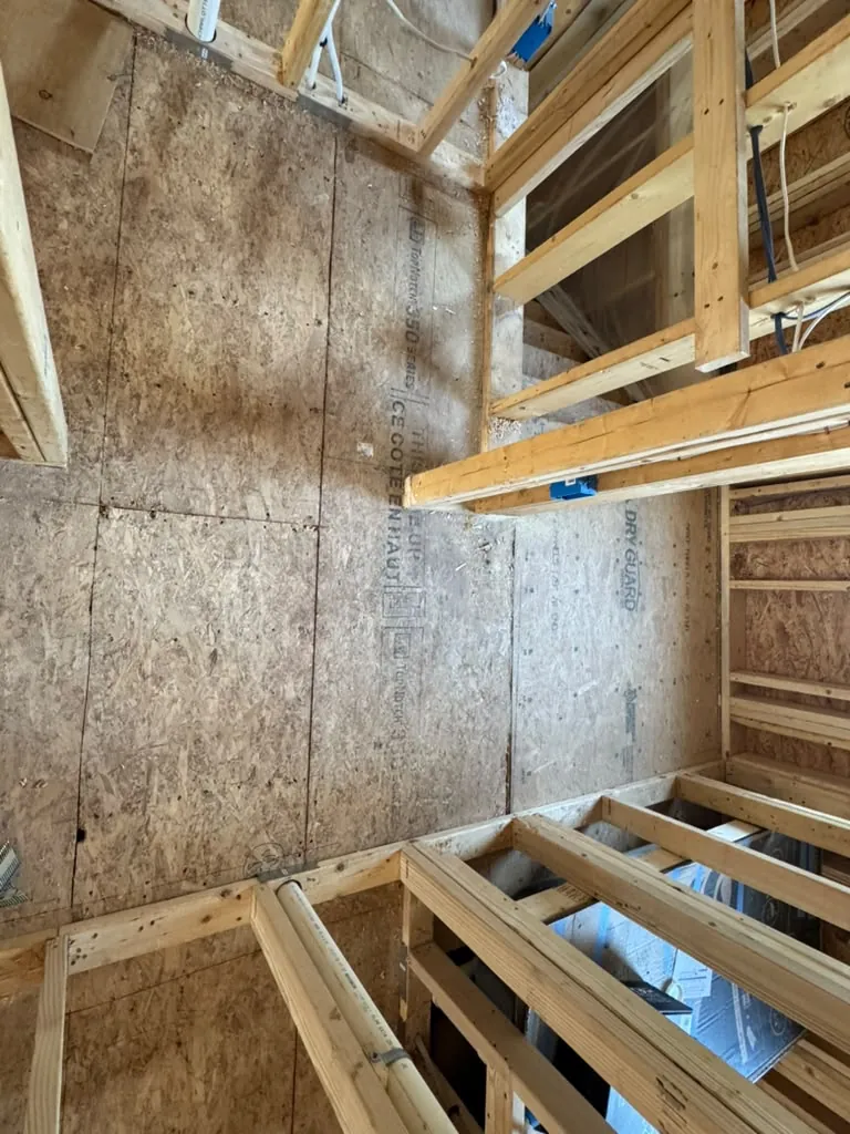New subfloor and stud walls in the addition, looking down the length of the room