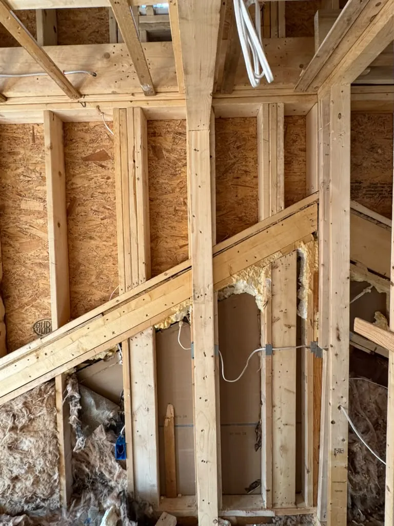Inside the new framing, with studs, joists and rough wiring run through the walls