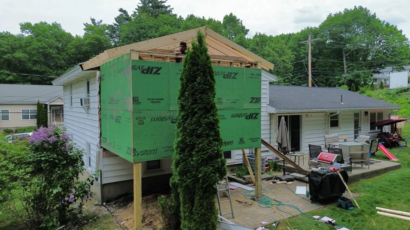 Second-storey addition framed and sheathed, carried on posts over the patio