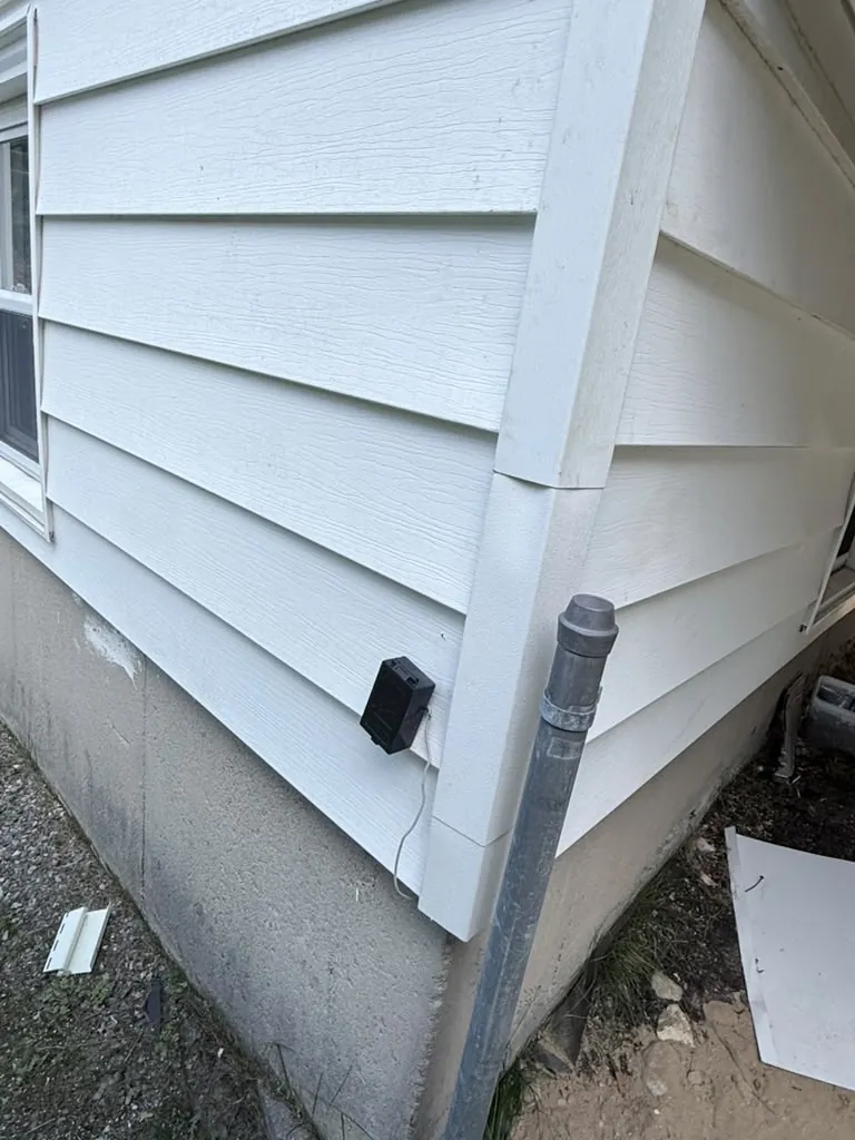 Close view of the new siding meeting the original wall, with the corner trim run true