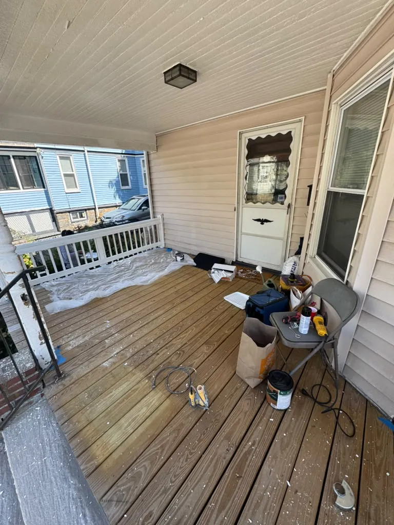 Old porch floor stripped and prepped, with drop cloths and paint cans in place