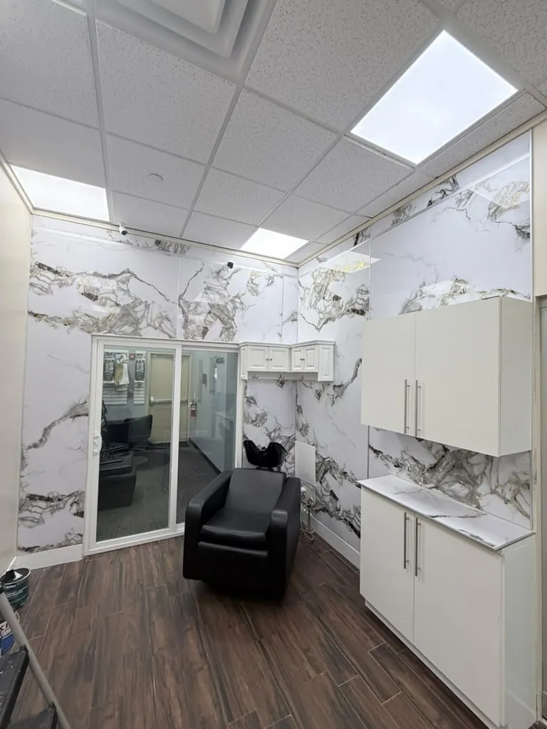 Commercial salon finished with large marble-look porcelain panels on the walls and wood-look tile underfoot